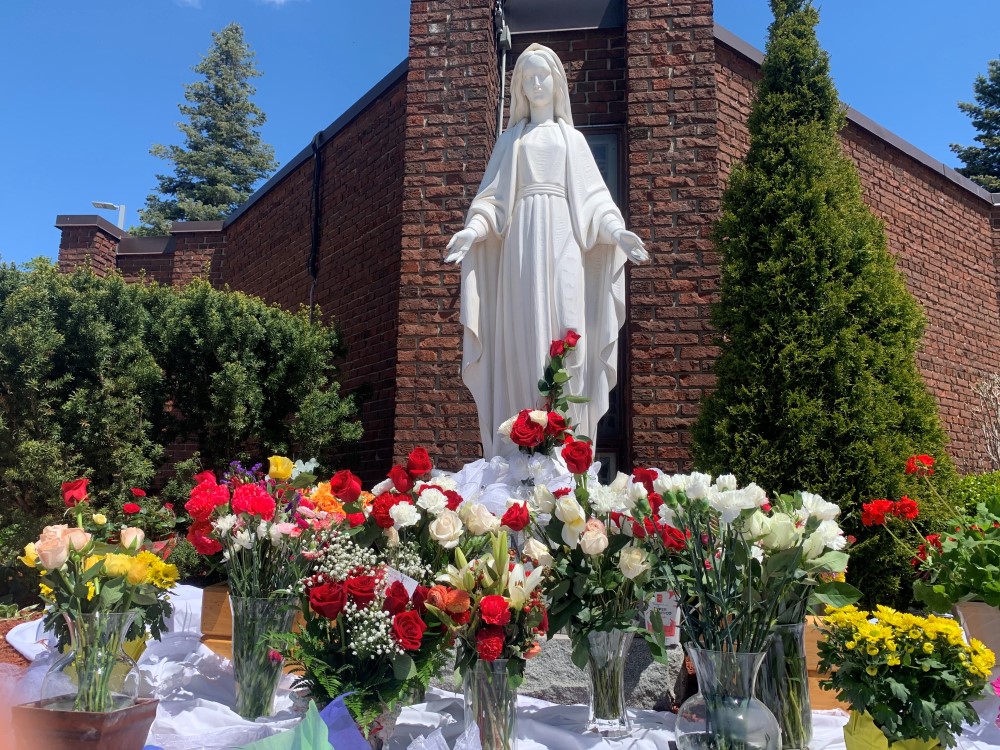 Statue of Mary surrounded by roses.