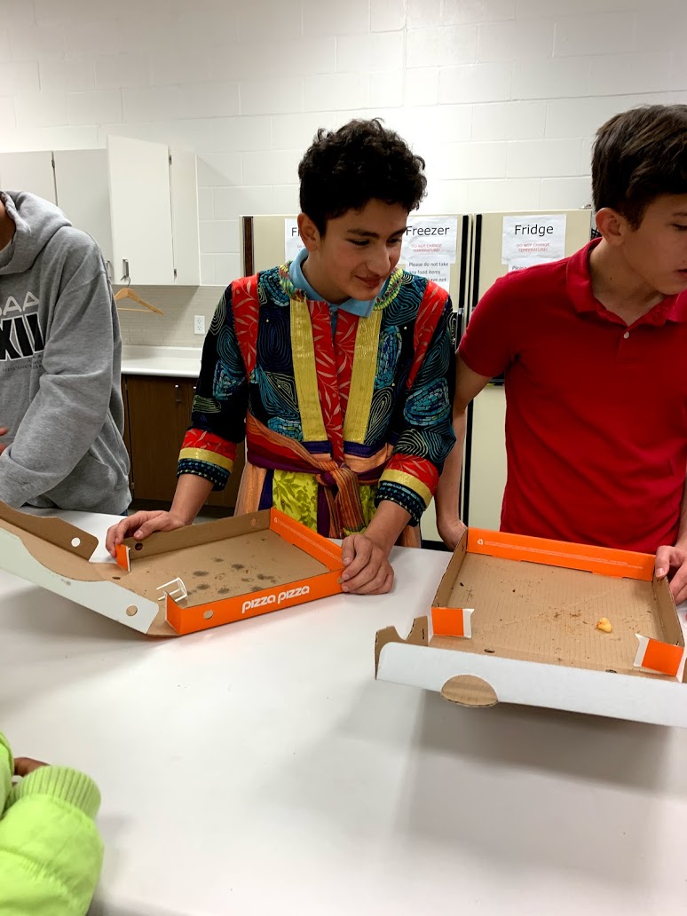 youth helping with pizza during movie night.